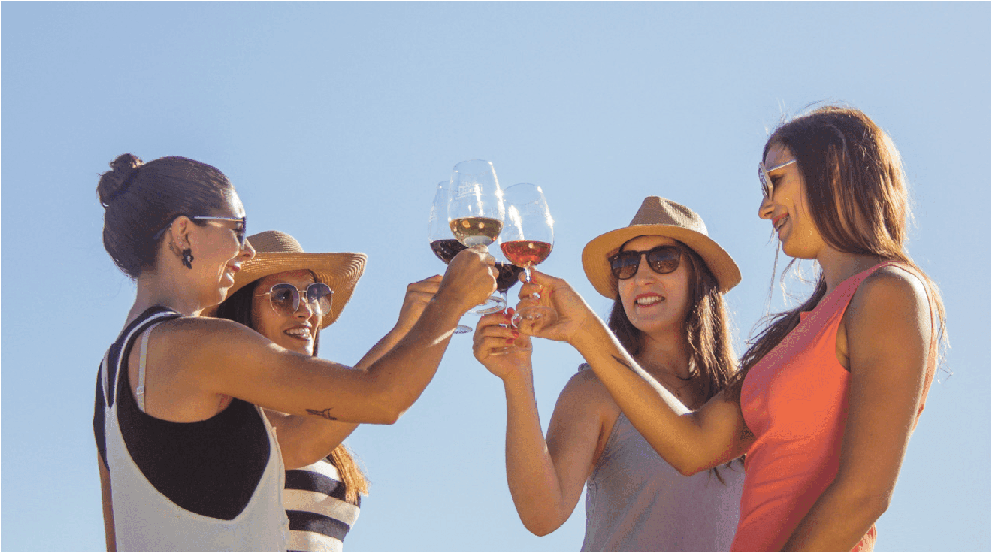 Grupo de amigas brindando con copas de vino al aire libre
